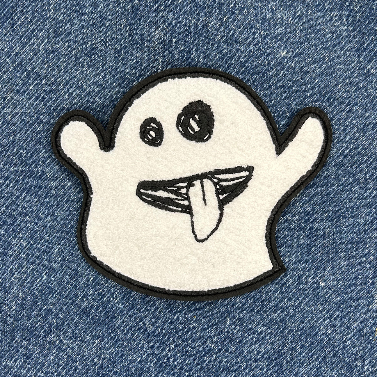 soft fuzzy patch of a hand drawn ghost sticking it's tongue out.